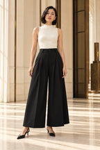 Pantalon large noir taille haute porté de face, sans foulard