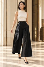 Pantalon fluide noir en mouvement, foulard noué sur le côté