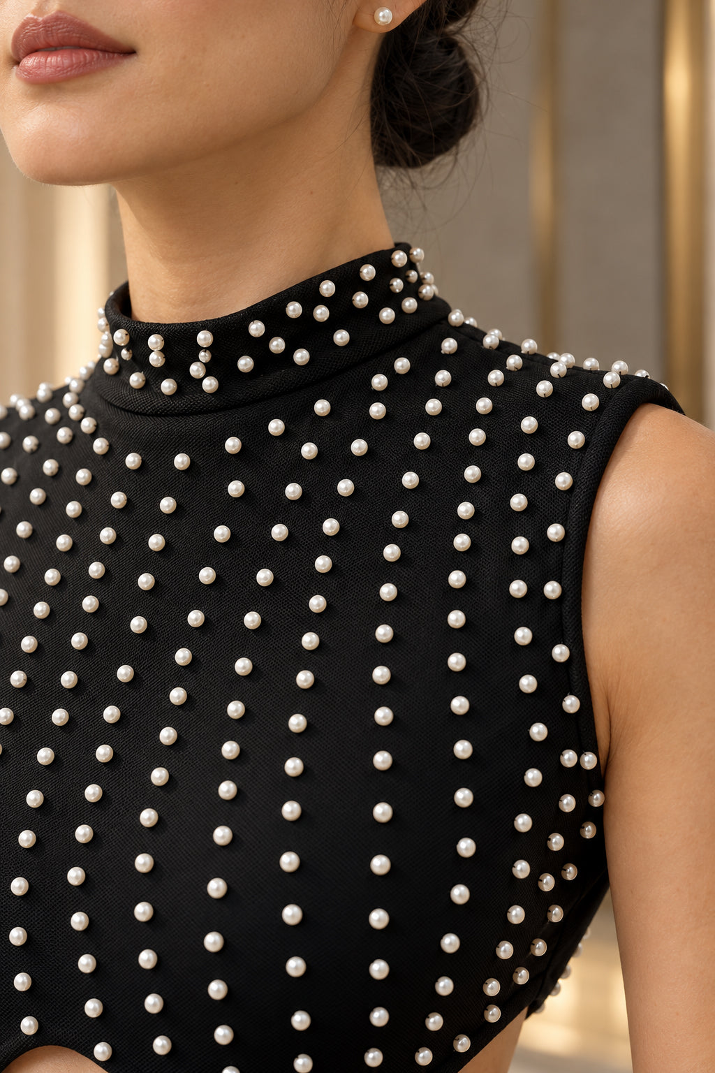 Gros plan sur les perles et le col montant de la robe noire