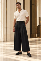 Pantalon large noir unisexe porté par un homme avec polo et mocassins