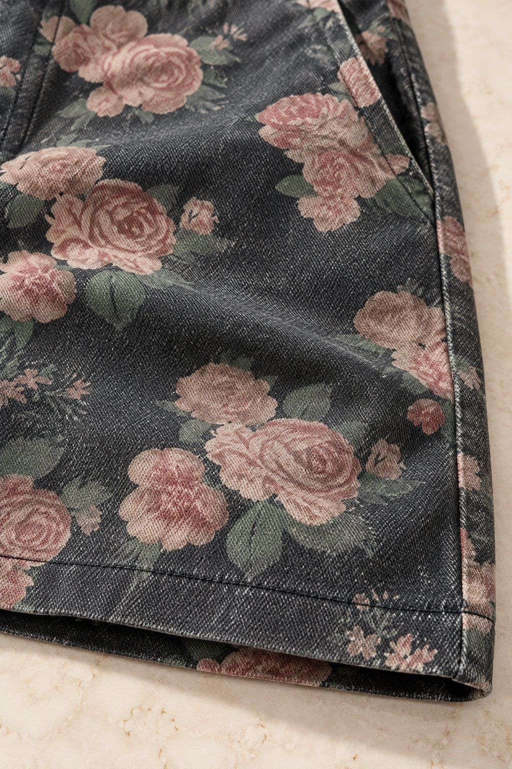 Détail de l'imprimé fleurs roses sur denim anthracite et de l'ourlet surpiqué