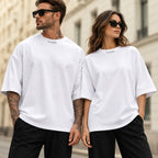Homme et femme portant le t-shirt oversize premium blanc DIFFERENT avec lunettes de soleil, dans une rue parisienne – DIFFERENT Paris