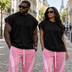 Homme et femme portant le débardeur oversize noir effet spandex brodé DIFFERENT avec jogging rose à bandes, près de la tour Eiffel – DIFFERENT Paris