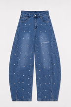 Jean femme DIFFERENT bleu stone vu de face, coupe ballon taille haute avec rivets métalliques, logo imprimé et fentes au bas des jambes.