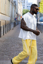 T-shirt blanc oversize unisexe DIFFERENT porté en look streetwear avec pantalon large jaune