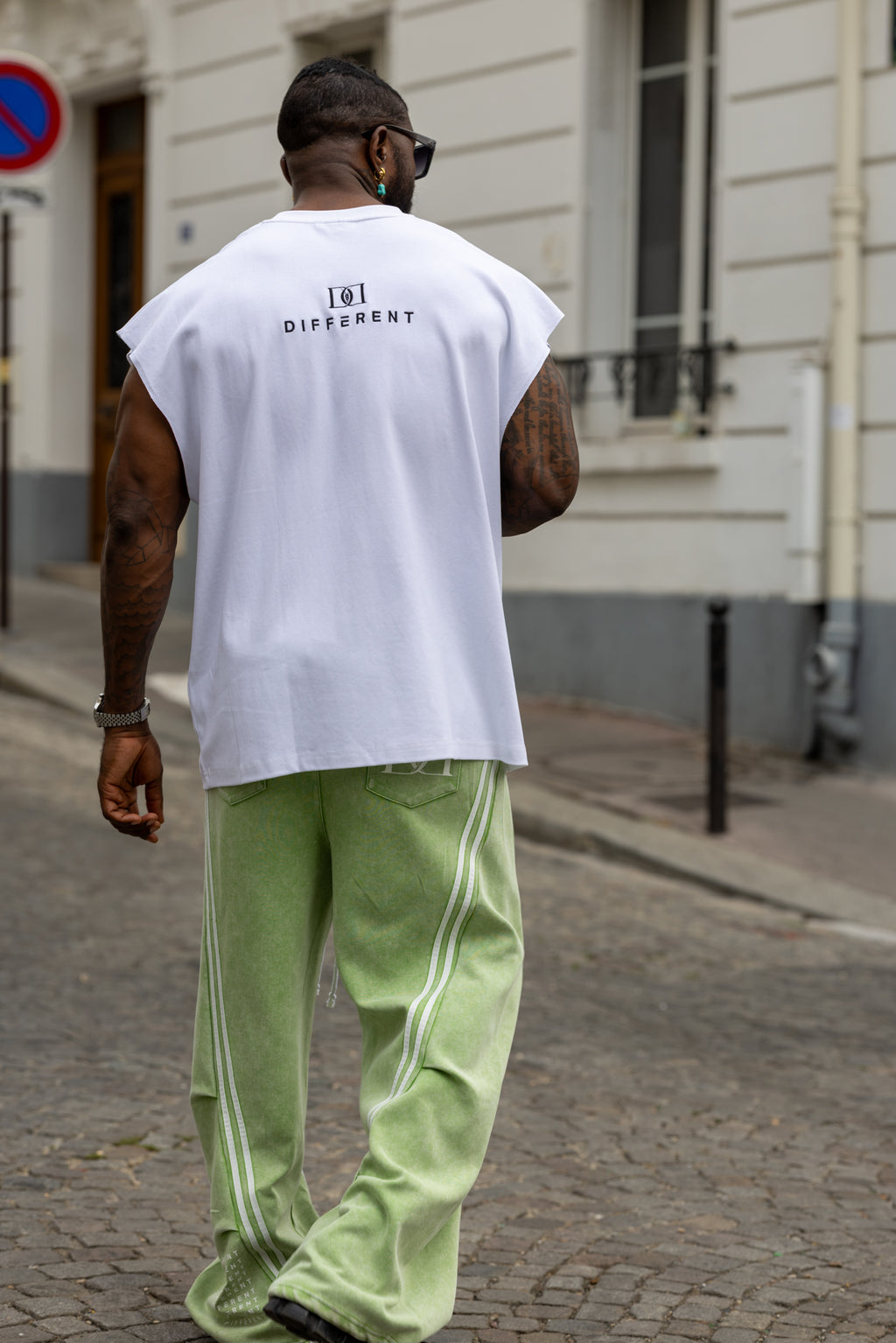 T-shirt streetwear DIFFERENT blanc et vert porté de dos avec pantalon oversize à bandes latérales