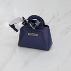 Mini sac DIFFERENT bleu marine avec foulard imprimé bleu et blanc, forme structurée et logo métallique.