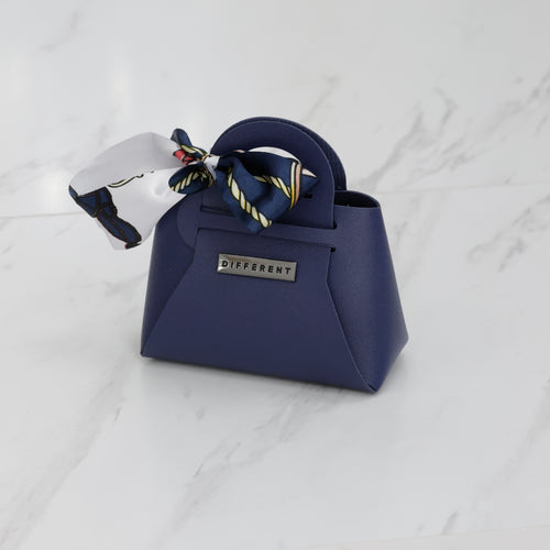Mini sac DIFFERENT bleu marine avec foulard imprimé bleu et blanc, forme structurée et logo métallique.