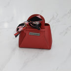 Mini sac DIFFERENT rouge avec foulard imprimé noir, rose et blanc, poignée rigide et finition effet cuir.