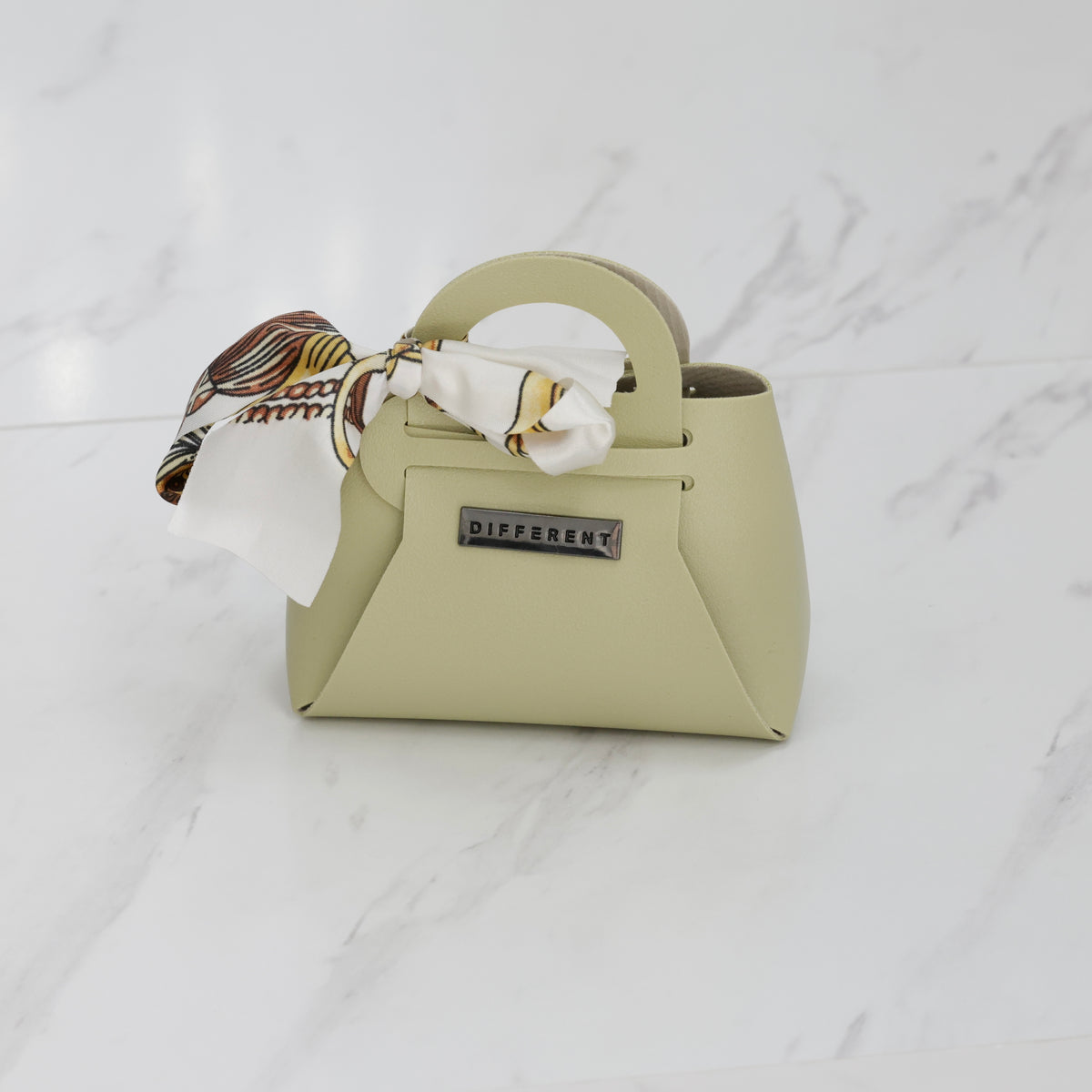 Mini sac DIFFERENT vert sauge avec foulard imprimé blanc et marron, design structuré et poignée arrondie.