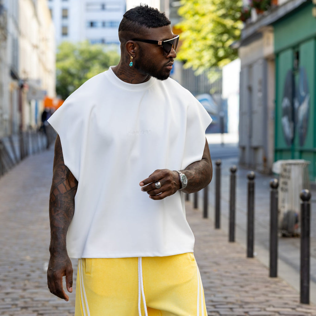 T-shirt oversize blanc unisexe DIFFERENT avec logo brodé ton sur ton, porté avec pantalon streetwear jaune