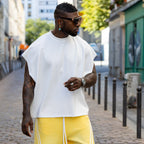 T-shirt oversize blanc unisexe DIFFERENT avec logo brodé ton sur ton, porté avec pantalon streetwear jaune