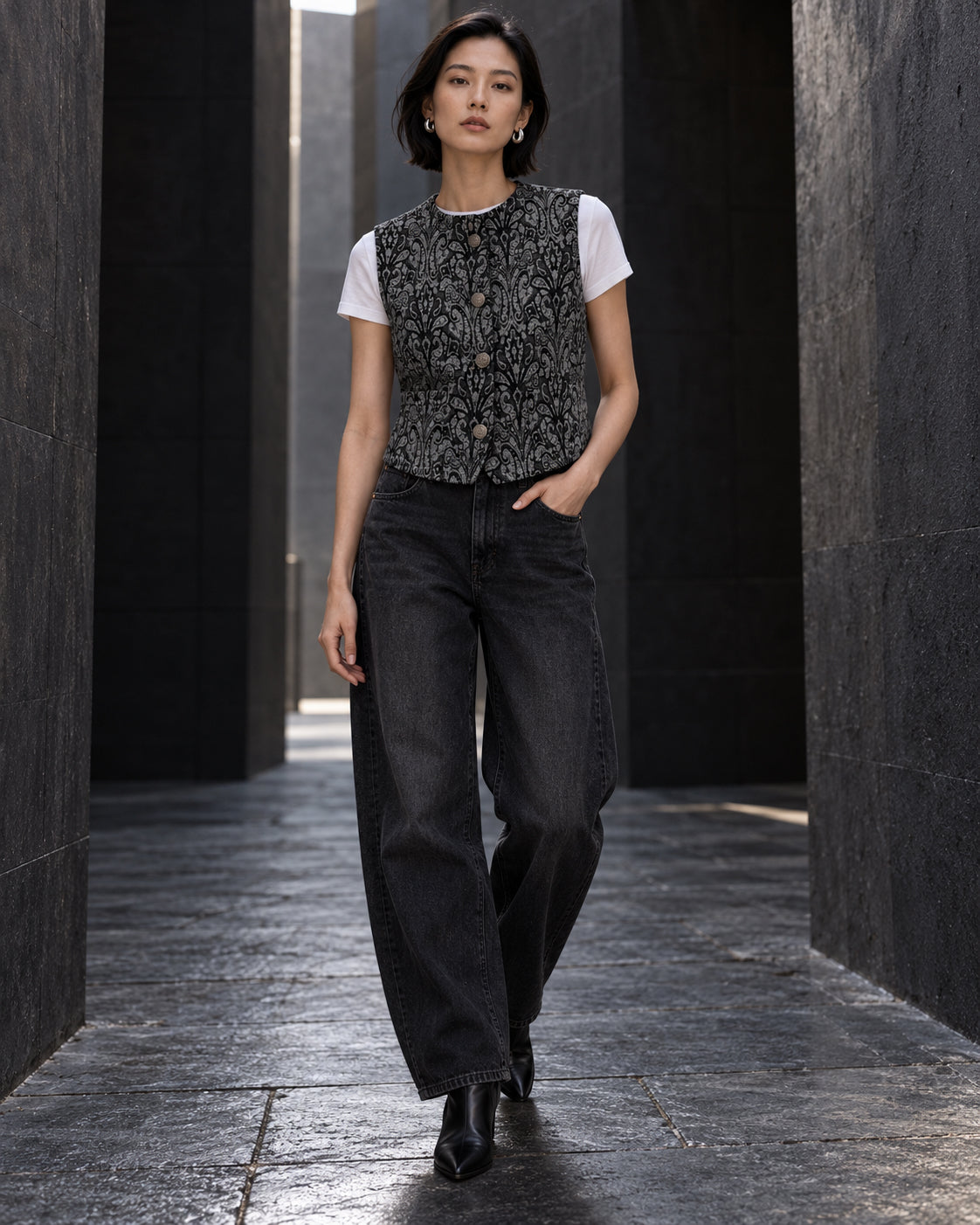 Femme portant le gilet court à motif baroque noir et gris DIFFERENT avec t-shirt blanc et jean noir large – DIFFERENT Paris