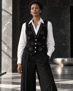 Femme portant le gilet noir structuré à clous argentés et diamants DIFFERENT avec chemise blanche et pantalon noir large – DIFFERENT Paris