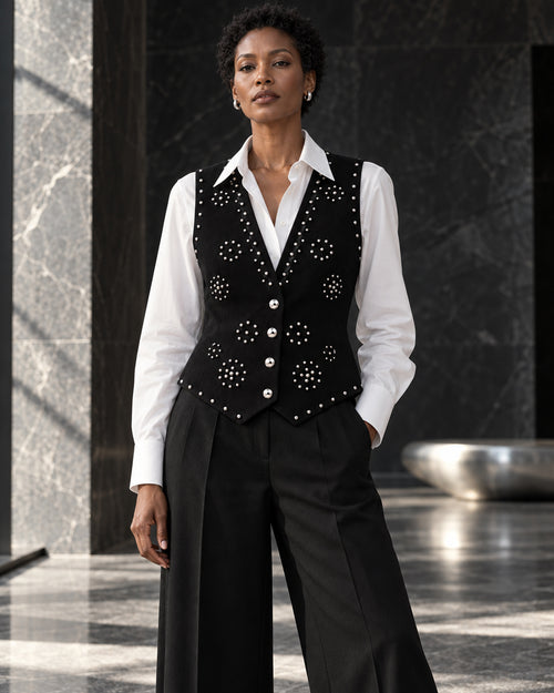 Femme portant le gilet noir structuré à clous argentés et diamants DIFFERENT avec chemise blanche et pantalon noir large – DIFFERENT Paris