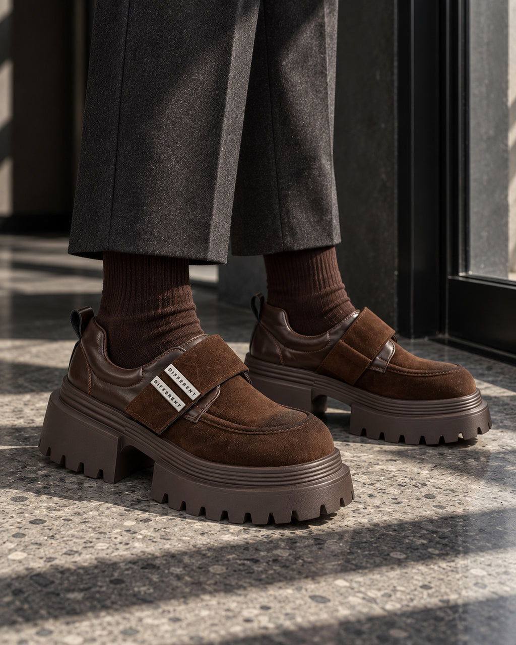 Chaussures à plateforme marron chocolat DIFFERENT portées avec pantalon gris et chaussettes marron – DIFFERENT Paris