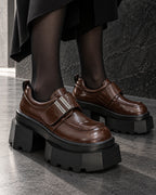 Chaussures femme à plateforme noire DIFFERENT en similicuir marron brillant, portées avec collants noirs – DIFFERENT Paris