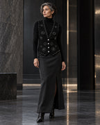Femme portant le gilet noir à clous argentés et diamants DIFFERENT avec col roulé noir et jupe longue noire – DIFFERENT Paris