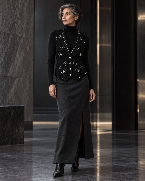 Femme portant le gilet noir à clous argentés et diamants DIFFERENT avec col roulé noir et jupe longue noire – DIFFERENT Paris