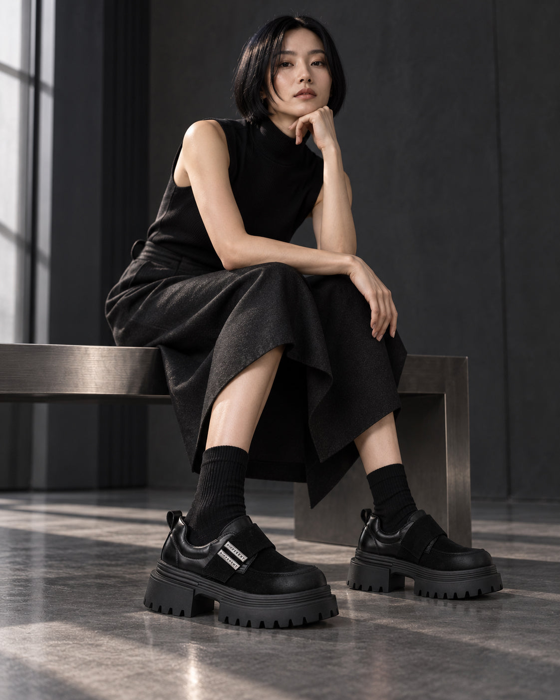 Femme assise en robe noire portant les chaussures à plateforme DIFFERENT avec chaussettes noires – DIFFERENT Paris