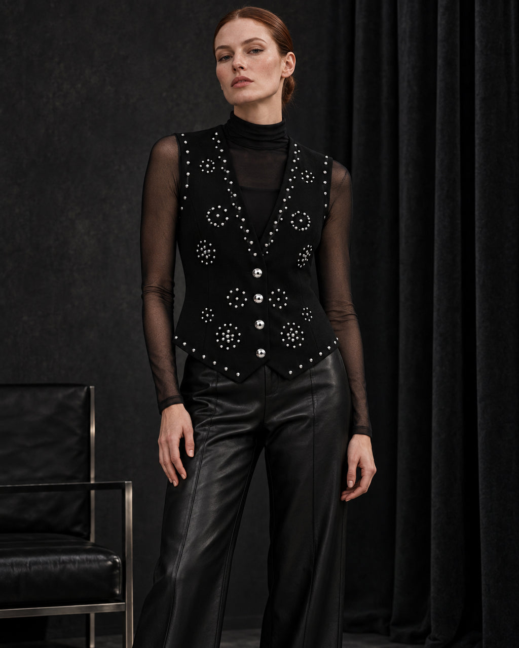 Femme portant le gilet noir à clous argentés et diamants DIFFERENT avec haut noir transparent et pantalon en cuir noir – DIFFERENT Paris