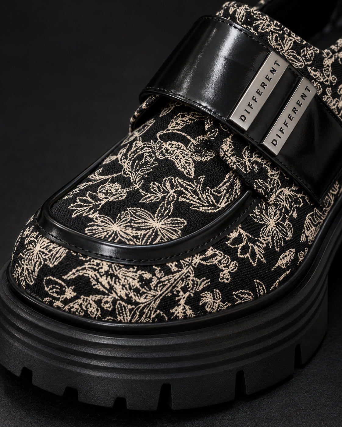 Gros plan sur le motif baroque noir et écru et la bride à plaques argentées DIFFERENT de la chaussure à plateforme – DIFFERENT Paris