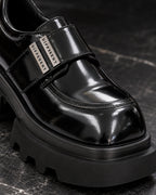 Gros plan sur la bride et les plaques argentées DIFFERENT de la chaussure plateforme femme noir brillant – DIFFERENT Paris