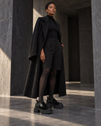 Look total noir avec manteau long, short et chaussures à plateforme femme DIFFERENT – DIFFERENT Paris