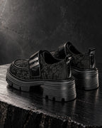 Paire de chaussures à plateforme noir motif floral DIFFERENT vue de trois quarts arrière, sur bois sombre – DIFFERENT Paris