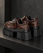 Paire de chaussures à plateforme marron brillant DIFFERENT vue de trois quarts arrière, talon et semelle noire épaisse – DIFFERENT Paris