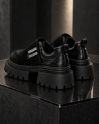 Paire de chaussures à plateforme noires DIFFERENT vue de trois quarts arrière, semelle crantée épaisse – DIFFERENT Paris