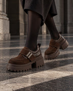 Chaussures à plateforme marron chocolat DIFFERENT portées avec jupe noire et collants, en marche – DIFFERENT Paris