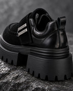 Gros plan arrière de la chaussure à plateforme noire DIFFERENT posée sur une roche, talon et semelle crantée – DIFFERENT Paris