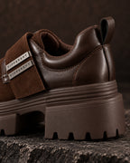 Gros plan arrière de la chaussure à plateforme marron chocolat DIFFERENT, bride et plaques argentées siglées – DIFFERENT Paris