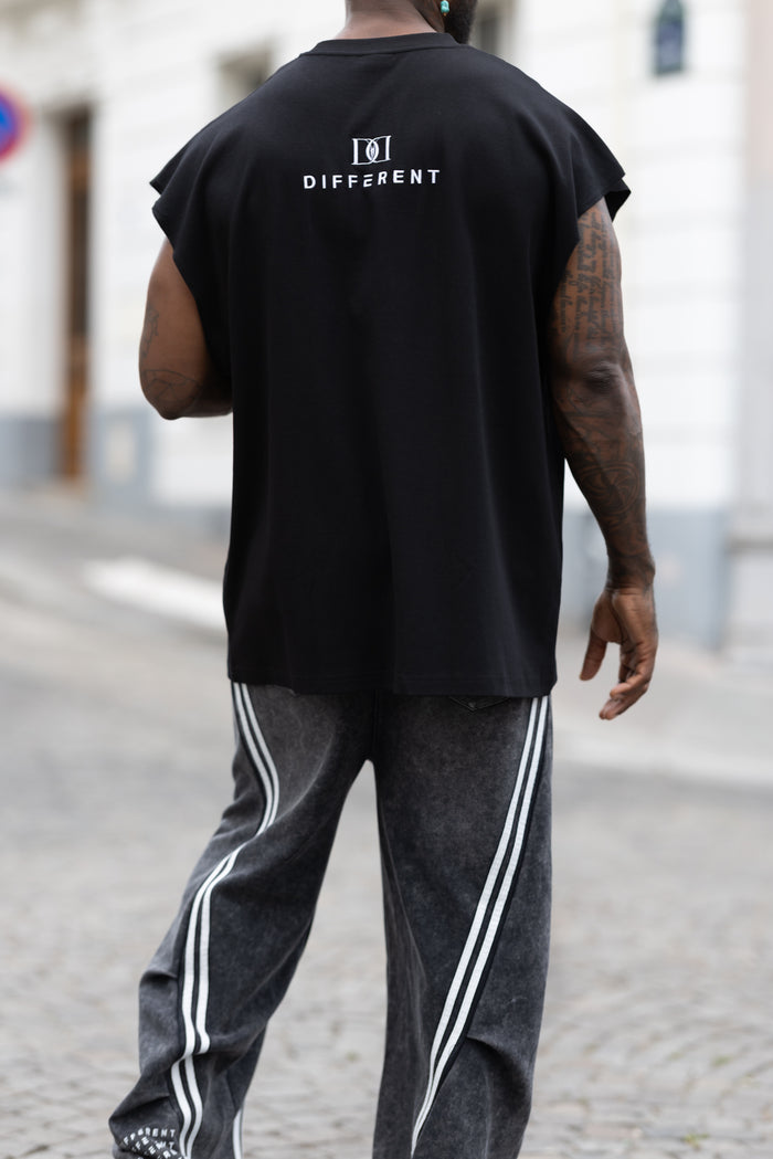 T-shirt oversize noir porté avec un jogging à bandes