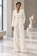 Tailleur blanc à fines rayures, veste longue fermée et pantalon jambe large, vue de face