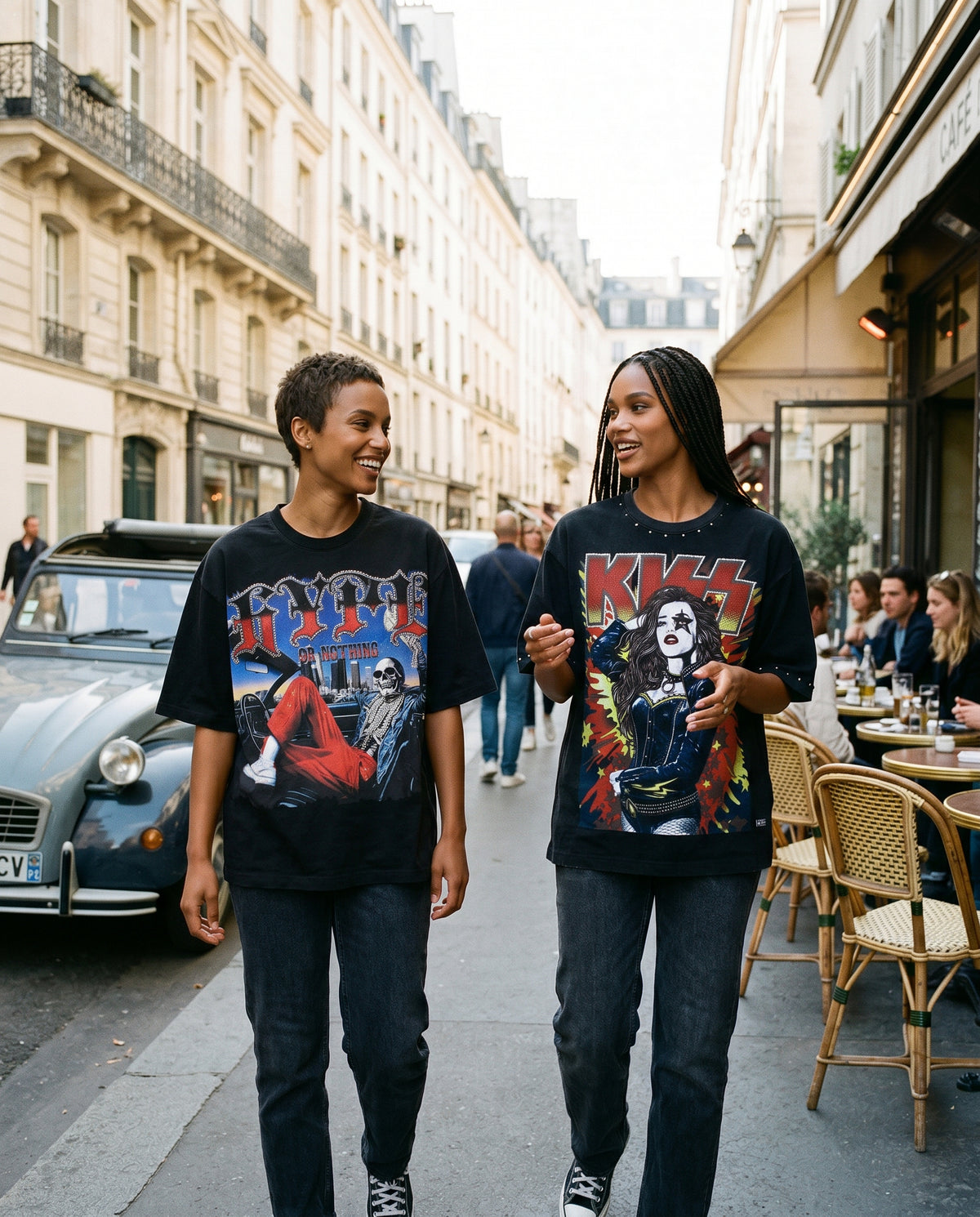 T-shirt Vintage Rockstar Kiss oversize noir, deux femmes marchant devant un café parisien – DIFFERENT Paris